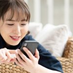 スマートフォンからメッセージを送る女性のイメージ