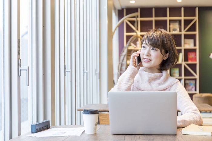 カフェの窓際で仕事をする女性社会人